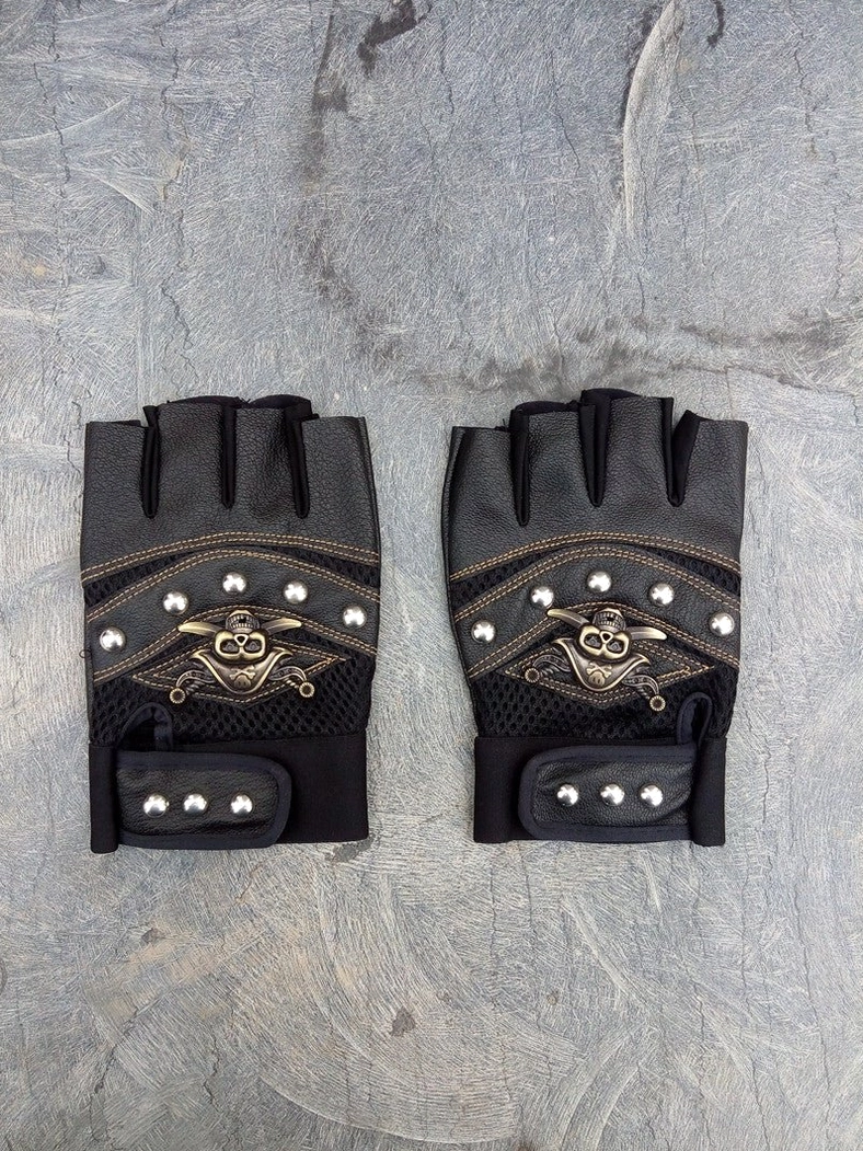 Fingerless skull rivet gloves flat lay showing complete design with embossed skull emblem, studs, and velcro closure