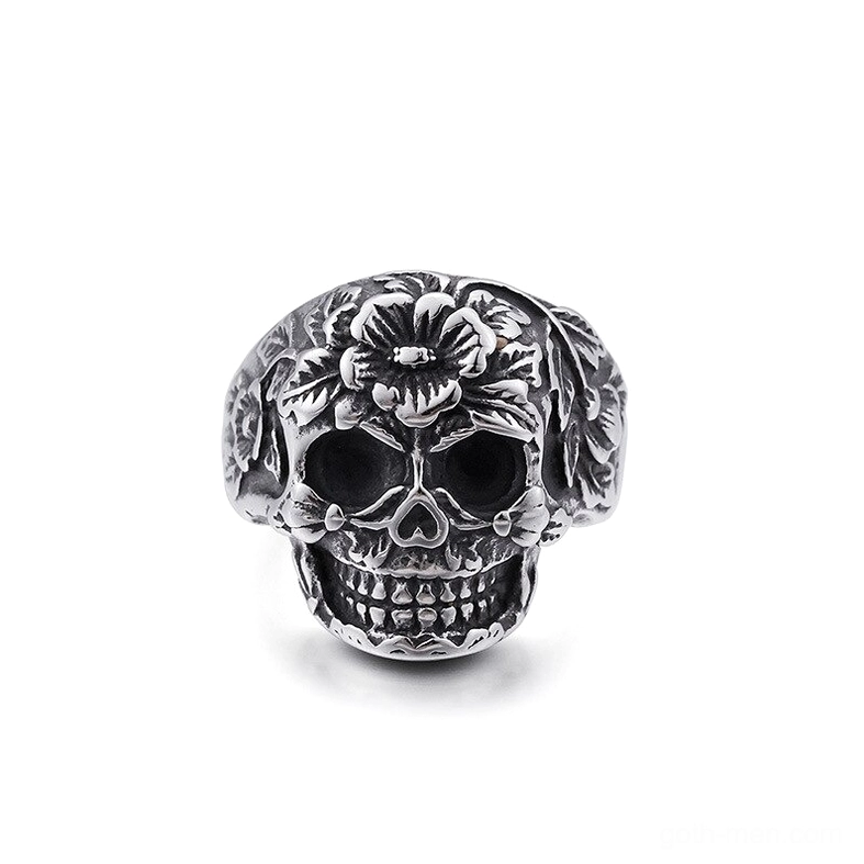 Ornate floral skull ring silver stainless steel front view, embossed flower patterns around skeletal face, gothic memento mori jewelry