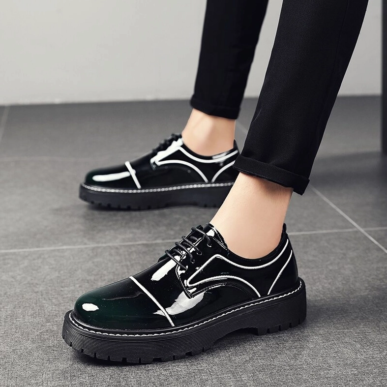 Model wearing dark green patent leather lace-up oxford dress shoes with thick platform sole