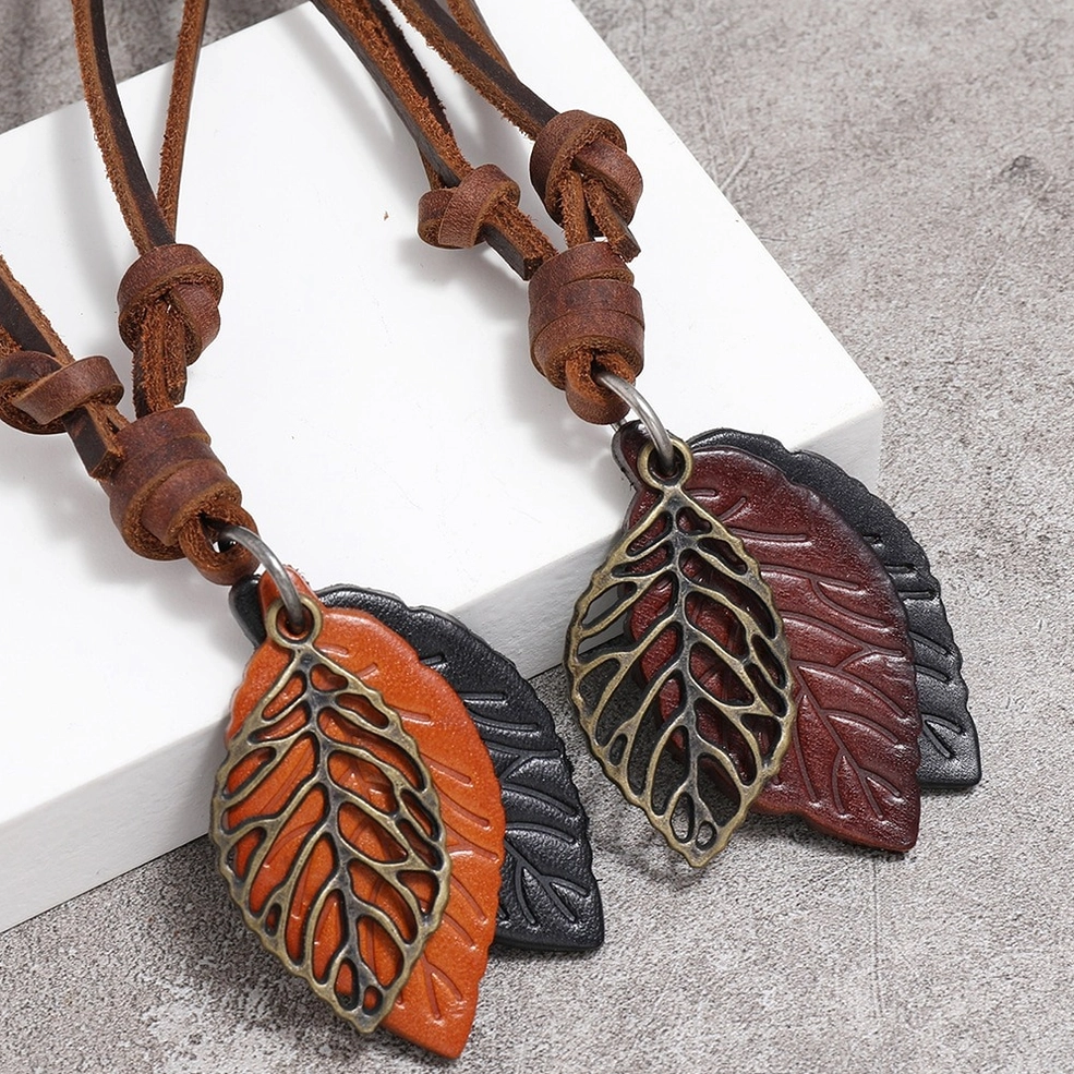 Close-up of genuine cowhide leather strap and bronze alloy leaf pendant on vintage gothic necklace - detail view