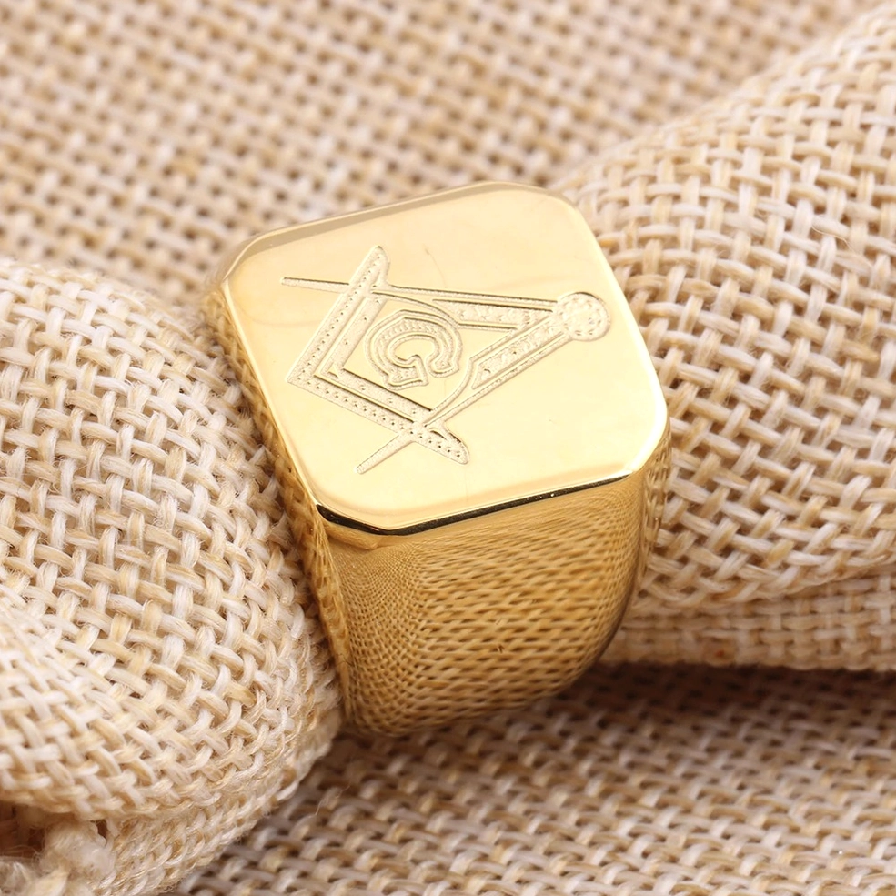 Gold Masonic signet ring top-down view showing engraved Freemasonry emblem on ring face, gothic dimensional detail