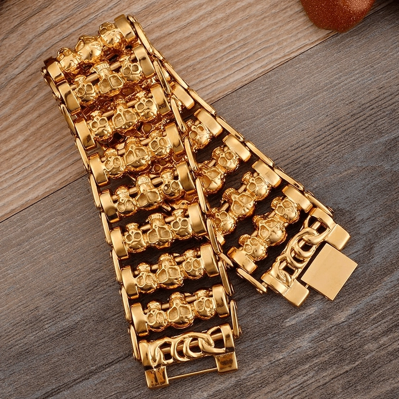 Detailed flat lay of gold gothic skull chain bracelet showing intricate skull link patterns
