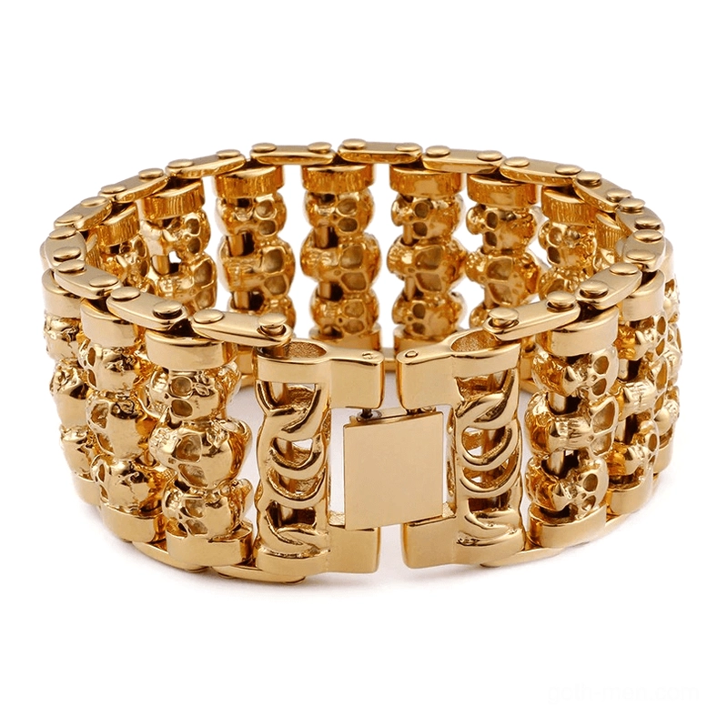 Gold tone gothic skull chain bracelet with wide band stacked skull design on white background