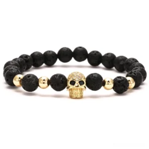Gold skull rhinestone gothic beaded stretch bracelet with black 8mm lava stone beads and gold spacer accents in flat lay view