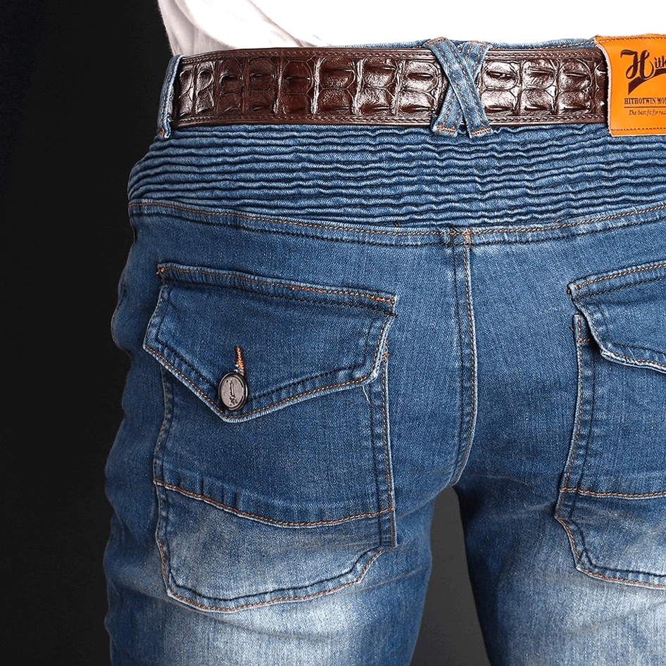 Rear close-up view of blue washed gothic protective jeans showing flap back pockets and branded leather belt detail