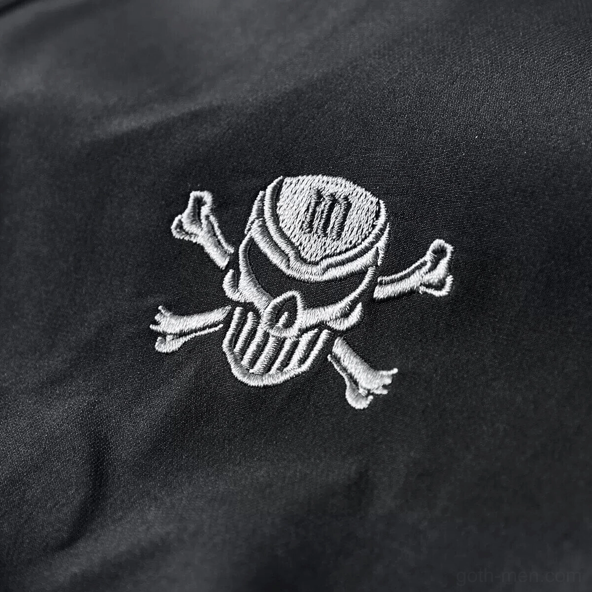 Detailed view of skull and crossbones embroidery on chest of gothic bomber jacket