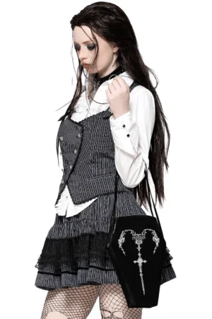 Gothic coffin shoulder bag worn by model in dark aesthetic outfit with fishnet tights and gothic styling, three-quarter view