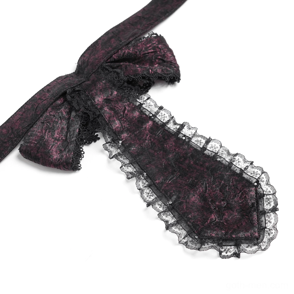 Close-up detail view of ornate cross charm and cameo brooch on burgundy Gothic cravat