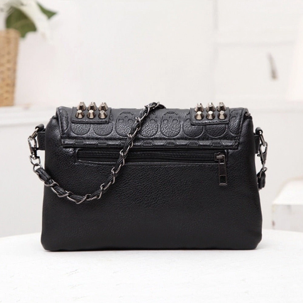 Rear view of black gothic skull rivet shoulder bag showing back zipper pocket chain shoulder strap and metal hardware details