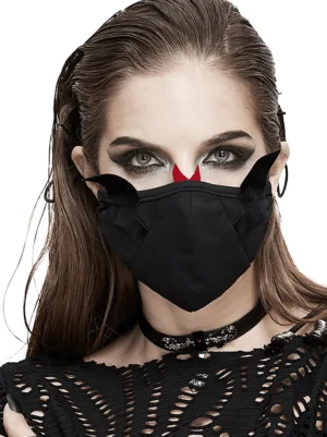 Gothic devil wing cotton face mask worn by model with goth makeup, front studio view showcasing black fabric and red horn decorations