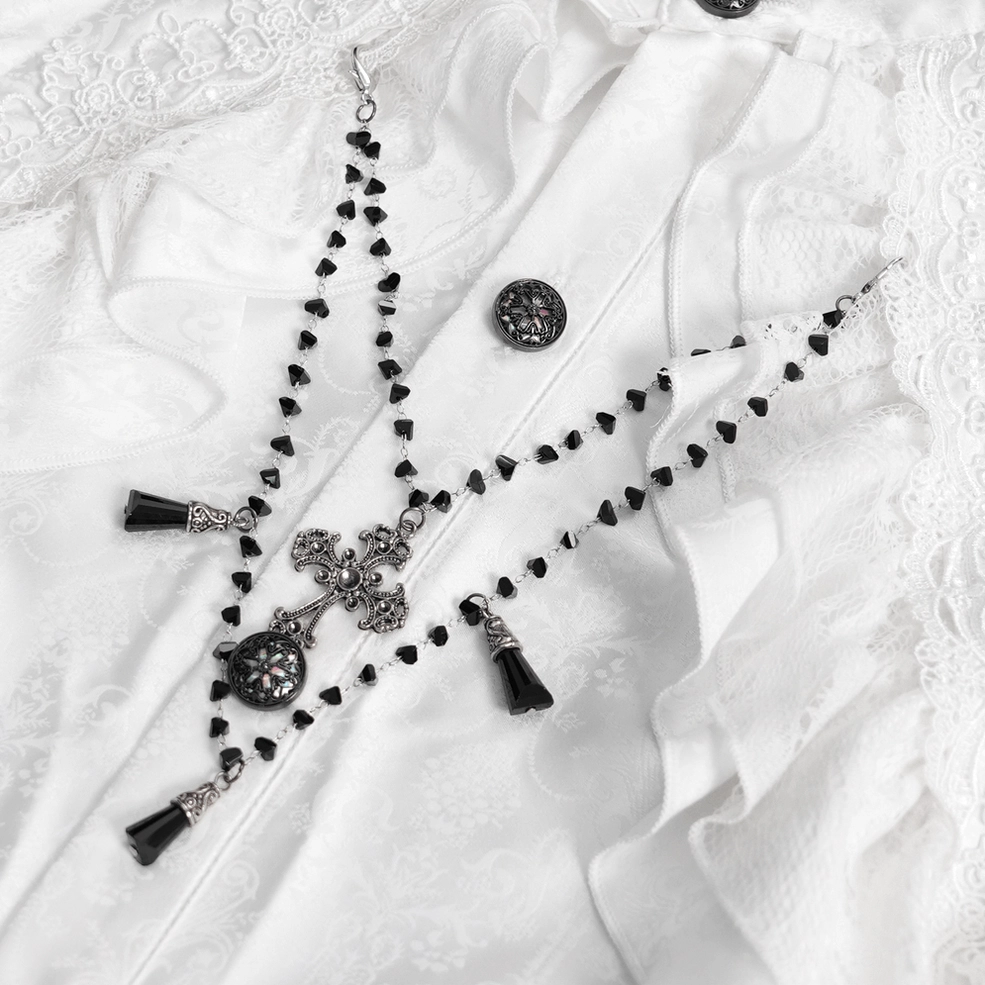 Flat close-up detail of Victorian gothic white shirt ornaments, black metal buttons, layered ruffles, and lace trim on jacquard textured fabric foundation