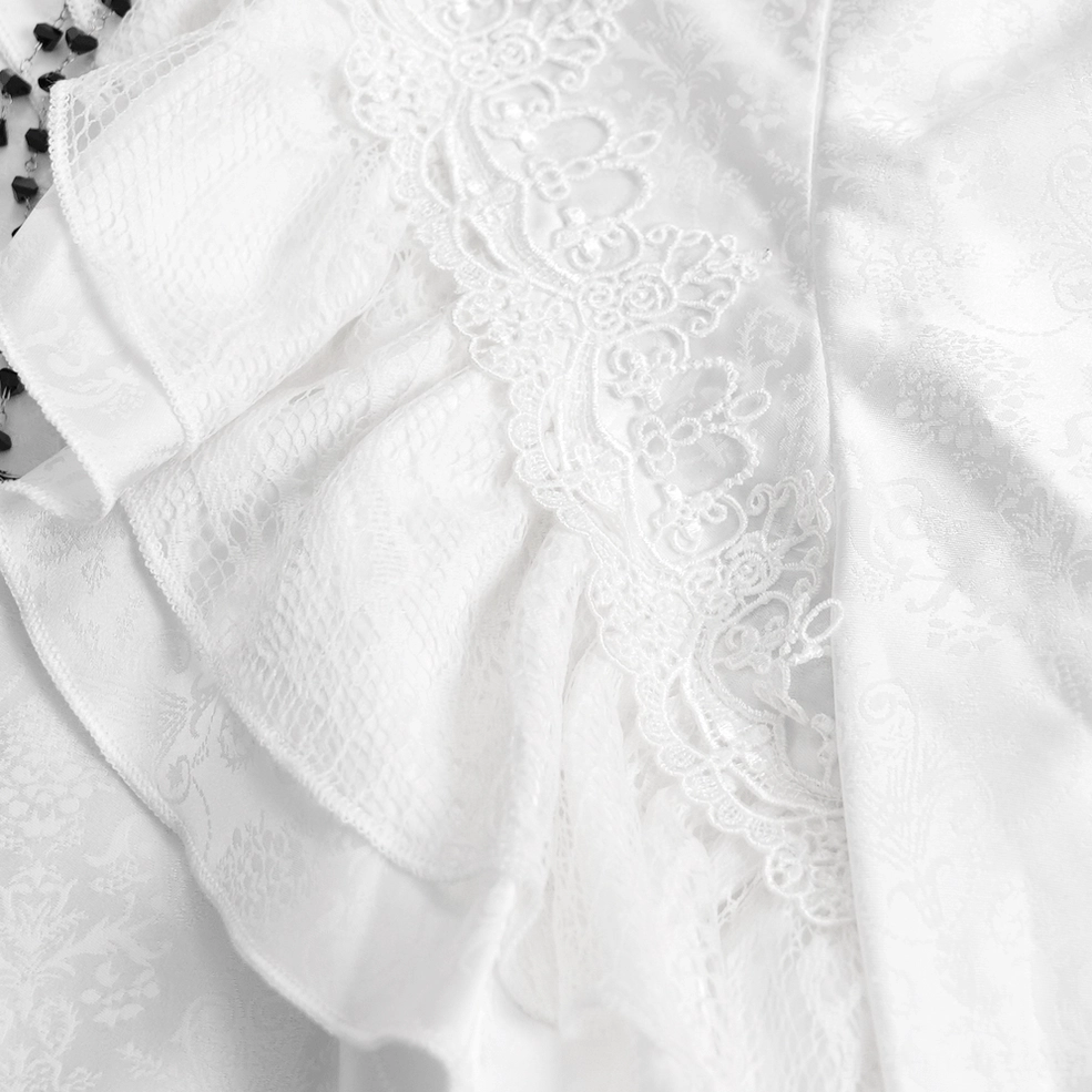 Side close-up detail of Victorian gothic white shirt showing layered ruffle trim and embroidered lace applique on jacquard fabric base, highlighting ornate decoration
