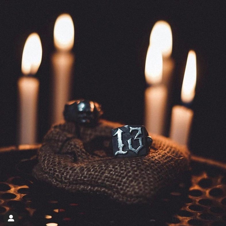 Number 13 gothic ring top view on burlap with candlelit dark atmosphere