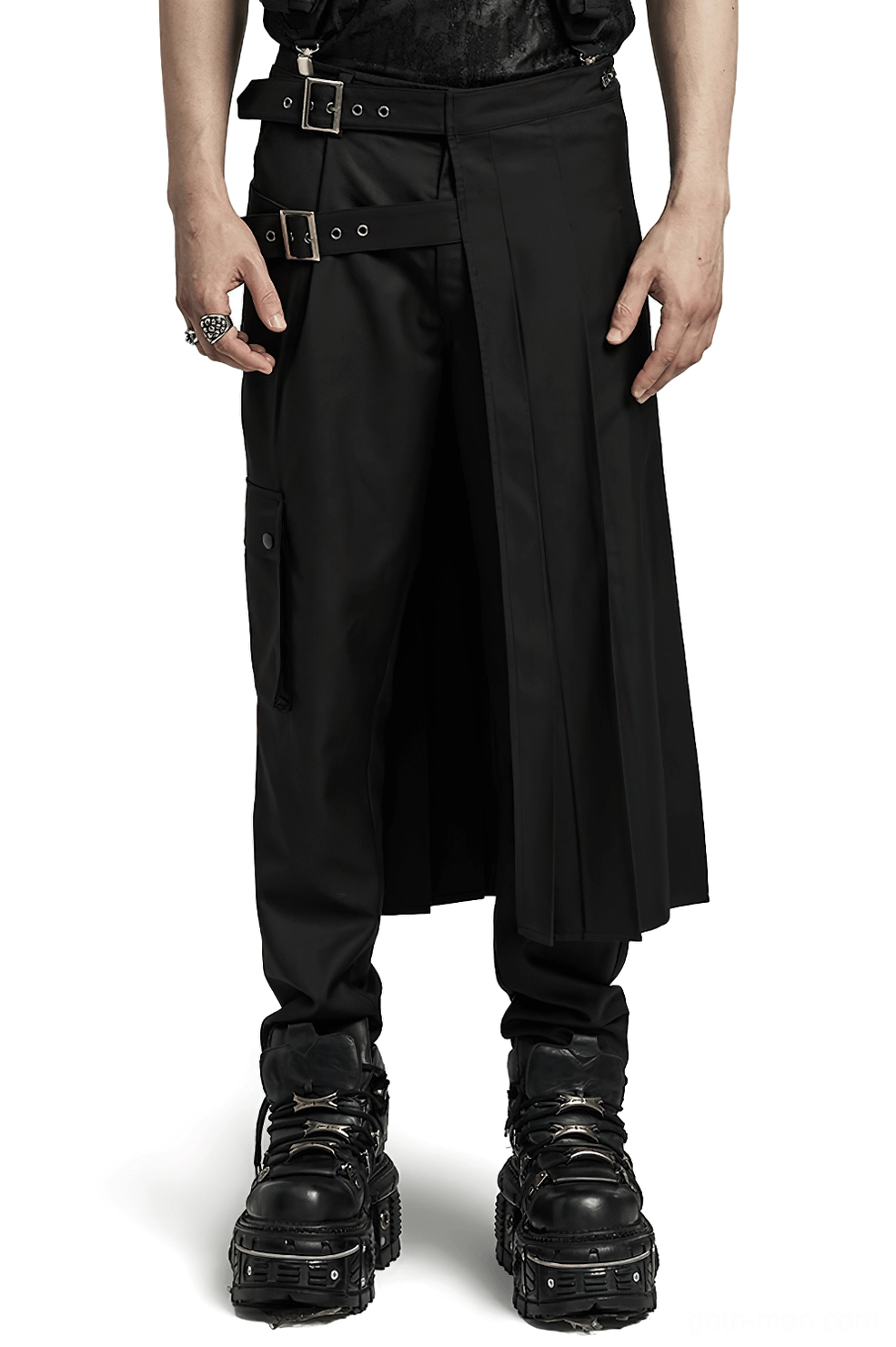 Black asymmetrical pleated gothic skirt with adjustable hardware buckle worn by male model, front three-quarter view showing structure and buckle detail