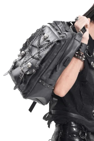 Close-up side view of gothic backpack showing metal skull accents and spiked trim detail on black synthetic leather