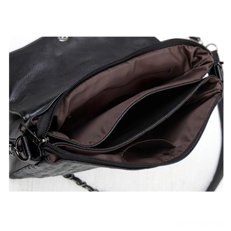 Interior close-up of gothic leather handbag showing brown fabric lining, multi-compartment pockets and zipper closure