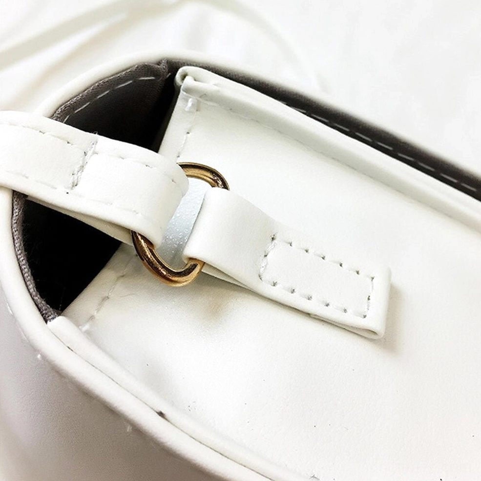 Close-up detail of faux leather shoulder strap with gold-toned metal buckle and stitched attachment