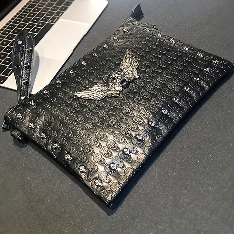 Black gothic clutch with studded edges and embossed skull pattern - office scene top view