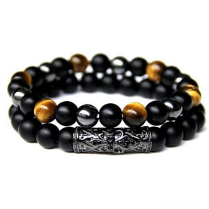 Double-layer gothic natural stone beaded bracelet with tiger's eye and carved black metal tube accents in flat lay view