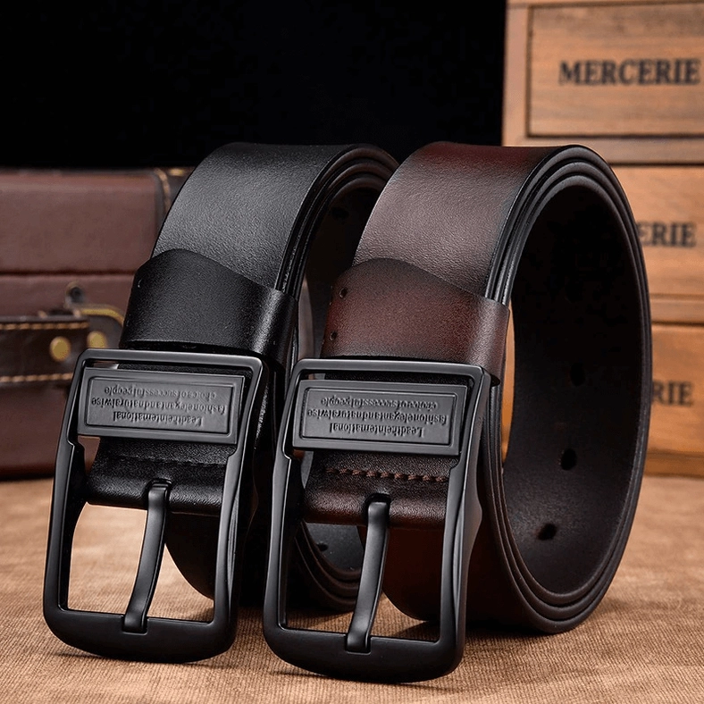Pair of gothic leather belts displayed on vintage wooden suitcase background