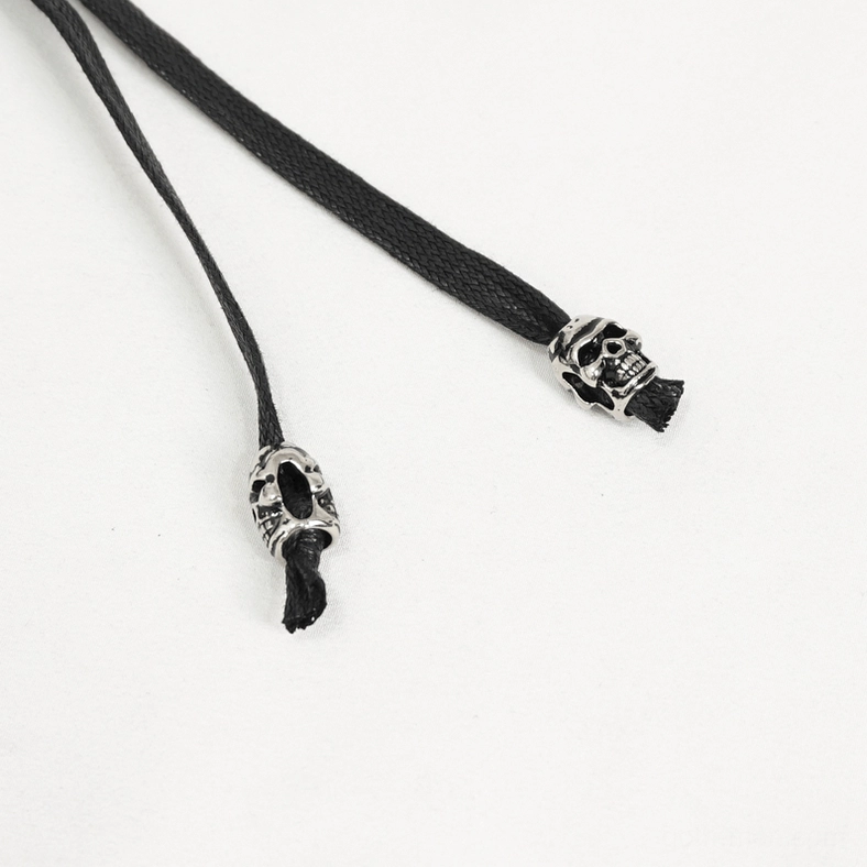 Close-up top-down view of skull charm drawstring straps and metal decorations on gothic punk belt