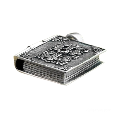 Right side view of hinged silver bible locket pendant showing detailed embossed decoration and compact geometric form