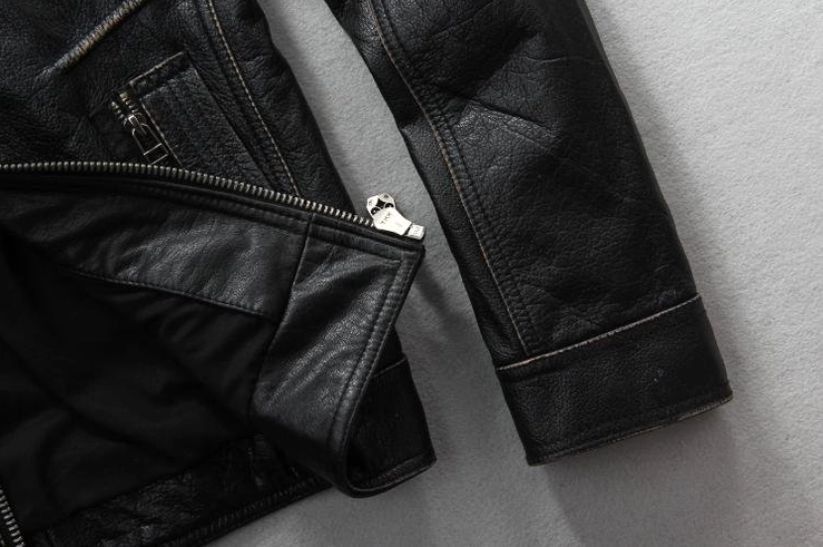 Vintage black leather biker jacket sleeve with metal zipper hardware and cowhide texture