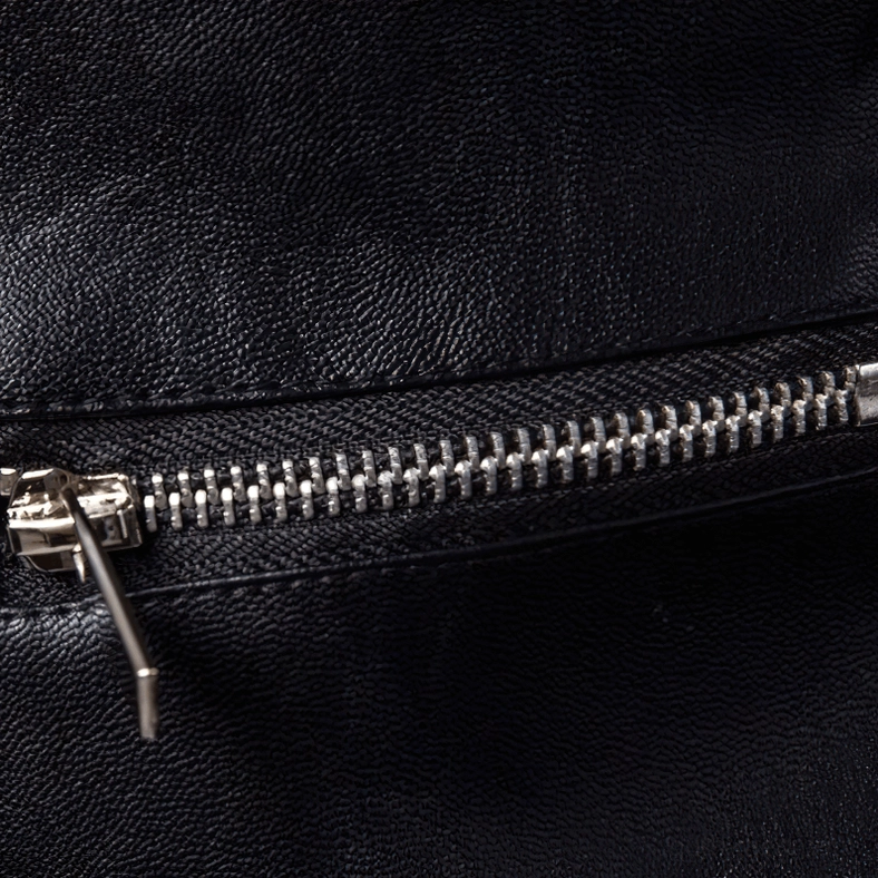 Detailed macro view of heavy-duty silver metal zipper teeth on gothic leather jacket