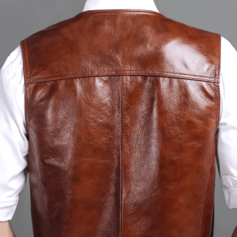 Back view of vintage brown leather biker vest on hanger, showing polished leather finish and center back seam