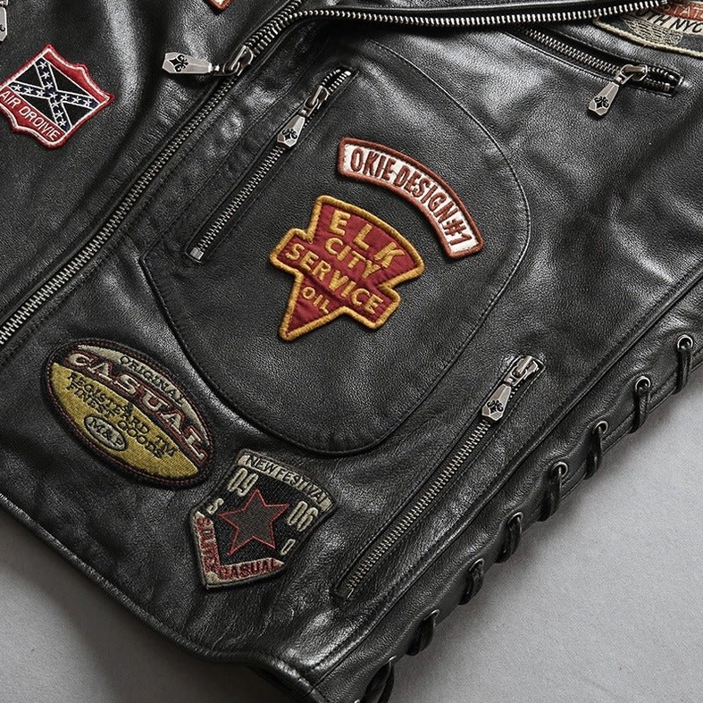 Front close-up of black leather biker vest with multi-zipper pockets and ELK CITY SERVICE embroidered patch
