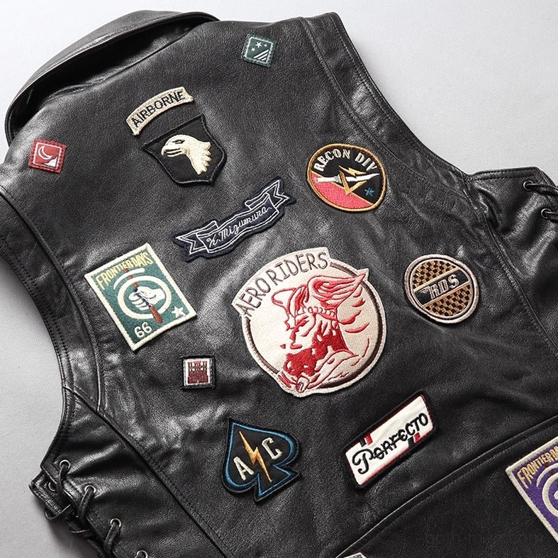 Men's black leather rider vest side angle showing lace-up panel and vintage service patch embroidery