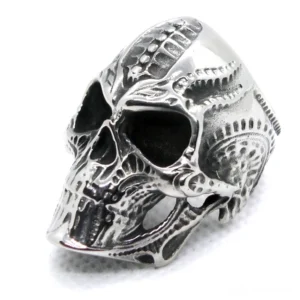Biomechanical skull ring left three-quarter view showing intricate carved patterns and silver-toned stainless steel construction