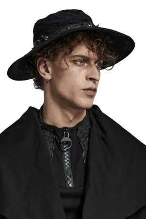 Black gothic distressed bucket hat with skull studs and spike embellishments worn by male model in side half-body view