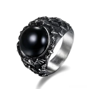 Gothic black onyx stainless steel signet ring with carved foliate and bat motif frame, front oblique view on white background