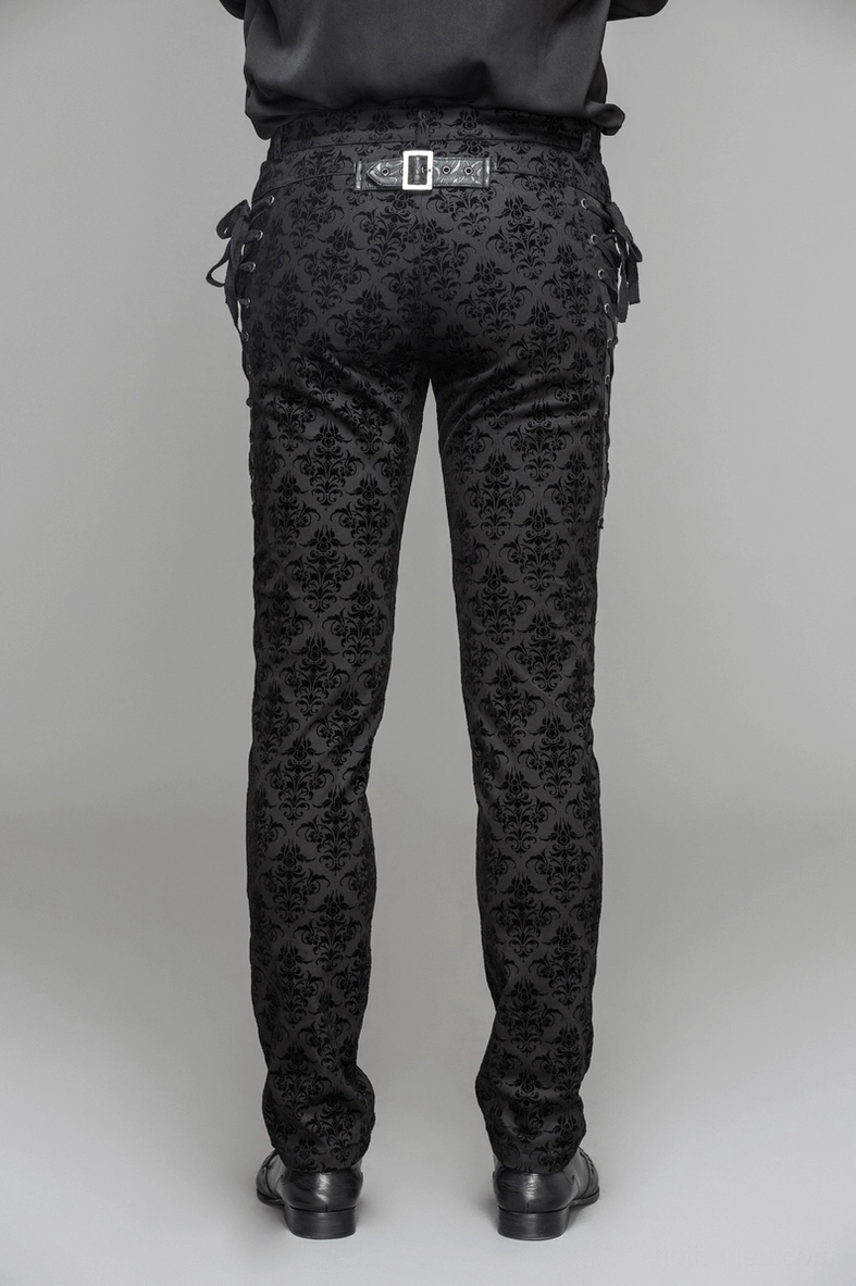 Lifestyle or styled view of gothic black slim-fit pants featuring lace-up side corset details and sophisticated damask pattern