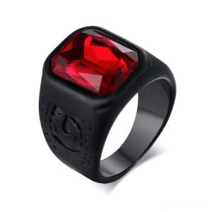 Black stainless steel gothic signet ring with red crystal glass stone, top-front view showing embossed emblem and matte black finish