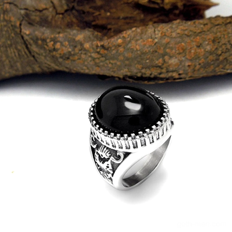 Close-up black gothic ring with carved stainless steel band, bold round gemstone, detailed metalwork