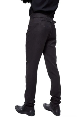 Back view of vintage-inspired black gothic slim-fit pants on male model, displaying rear belt adjuster and tapered leg design