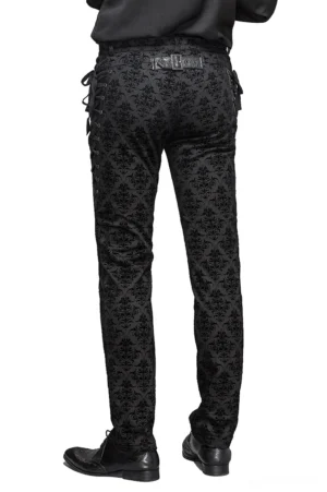 Rear full view of gothic black slim pants showing decorative leather belt plate, damask floral pattern, and lace-up side details