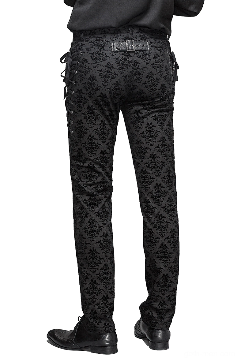 Rear full view of gothic black slim pants showing decorative leather belt plate, damask floral pattern, and lace-up side details