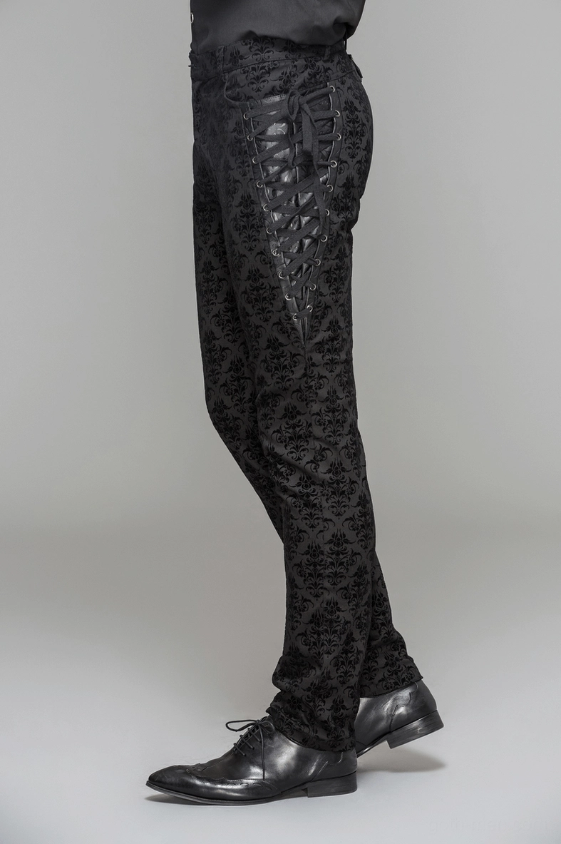 Flat lay or detail shot of gothic black slim-fit trousers highlighting the damask fabric weave and construction quality