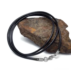 Black wax rope gothic necklace with stainless steel clasp, braided cord detail shown from oblique angle on stone texture background
