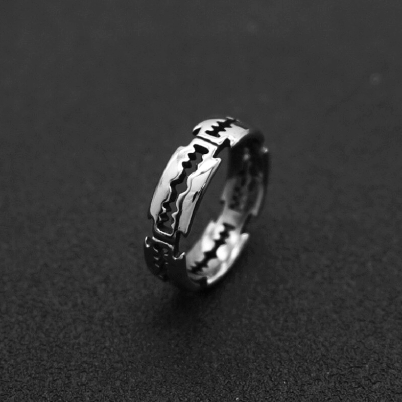 Dark silver gothic sawtooth blade ring with precision-cut details - dramatic black background showcase