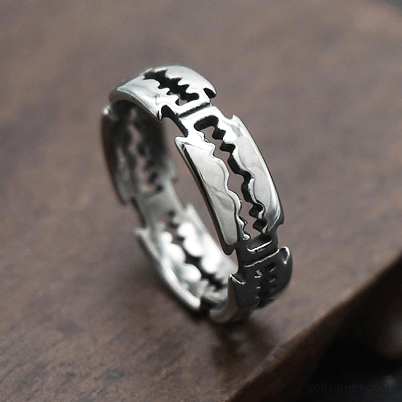 Stainless steel gothic blade ring with distressed metal finish - oblique side view on wood background
