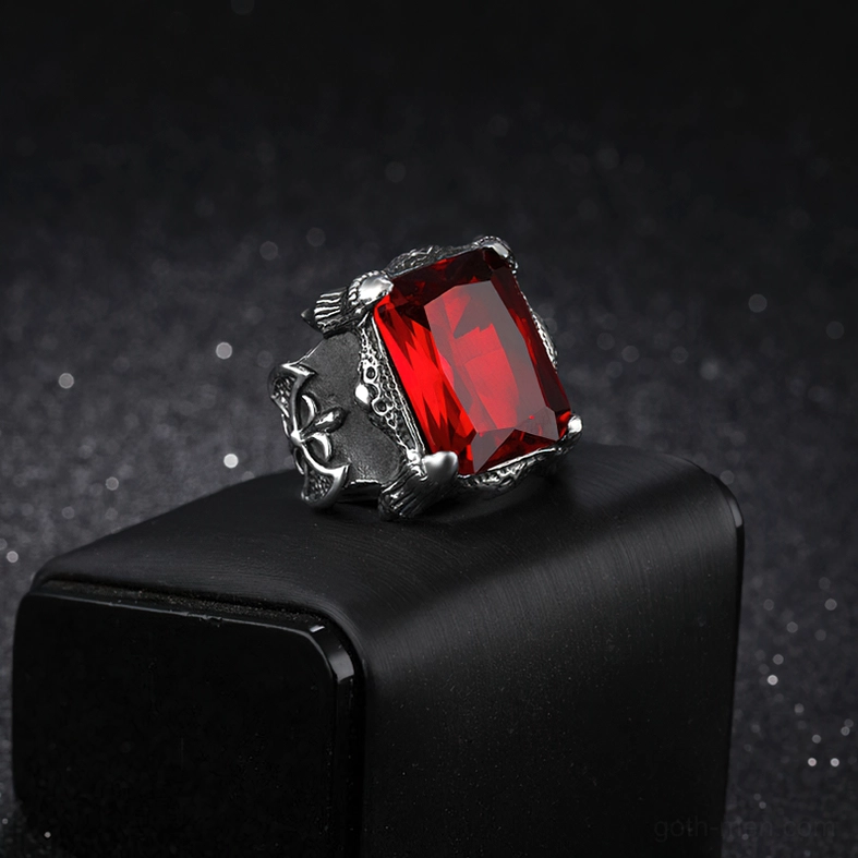 Side oblique view of compact Gothic blood red zircon ring displayed on black jewelry stand, featuring shiny faceted red gemstone and ornate stainless steel frame