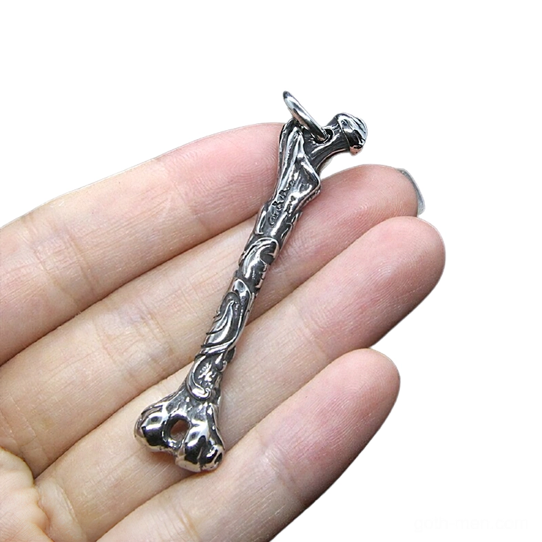 Stainless steel bone pendant worn on hand showing scale and bone-shaped design close-up overhead
