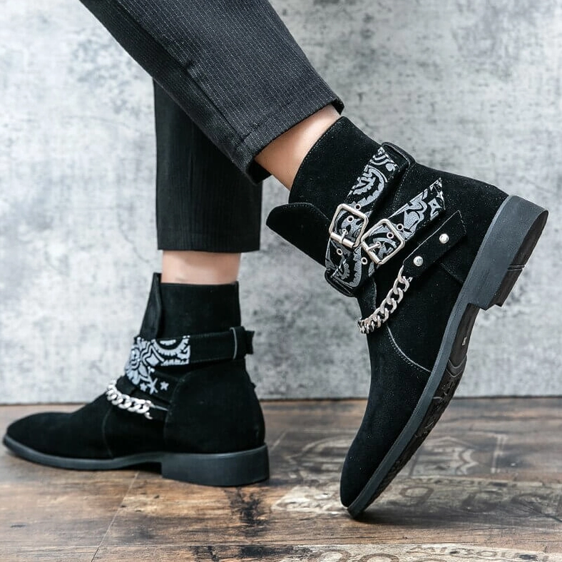 Close-up detail of black gothic boot buckle strap and chain hardware showing decorative elements craftsmanship