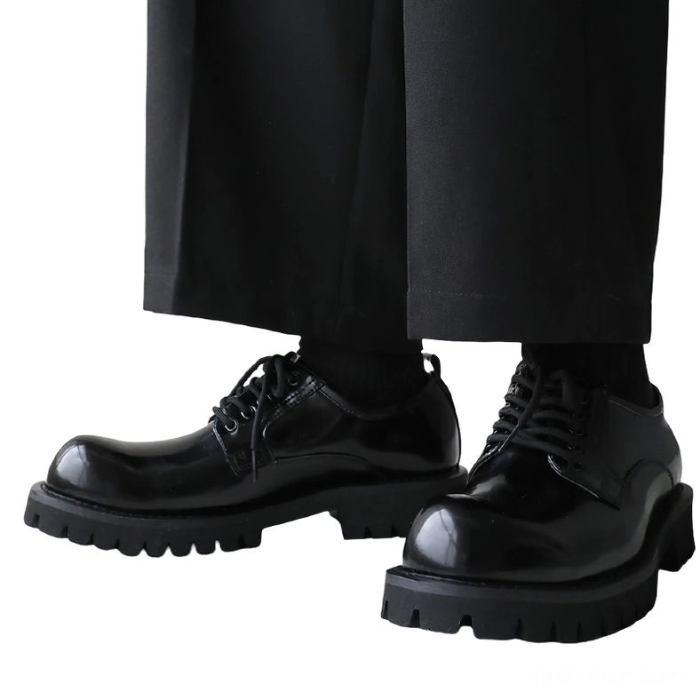 Styled side view of gothic platform derby boots paired with wide-leg black trousers formal alternative look