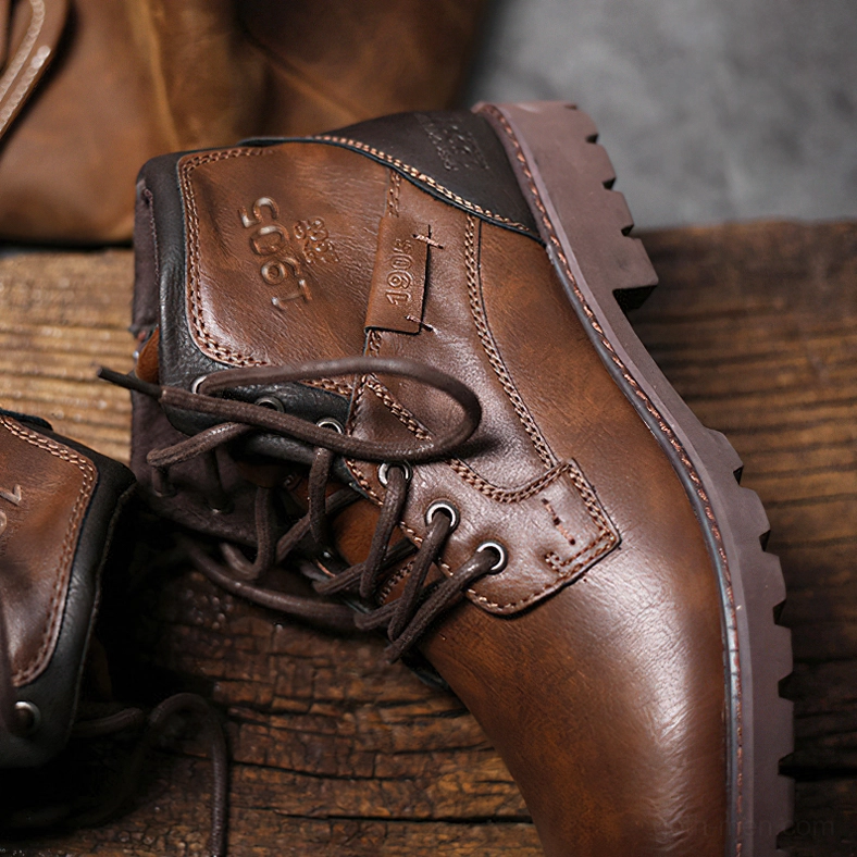 Black and brown gothic ankle boots showcase with lace-up closure and stitching detail