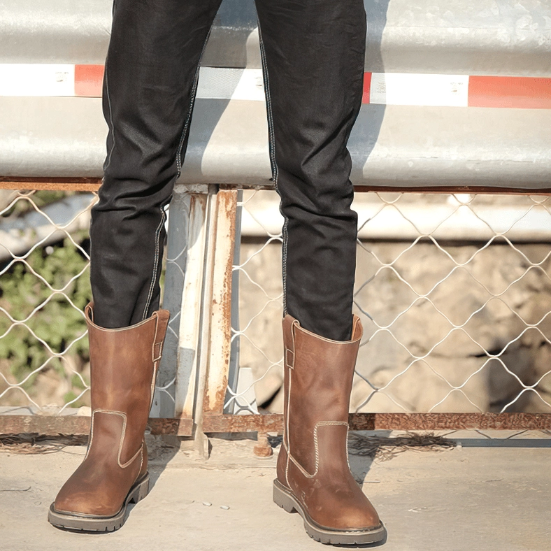 Brown gothic leather boots side rear view with lug outsole on model wearing jeans